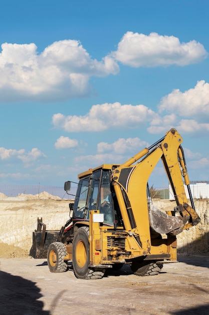 Excavatrice creusant dans le sol à la lumière du jour