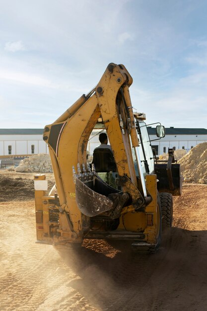 Excavatrice creusant dans le sol à la lumière du jour