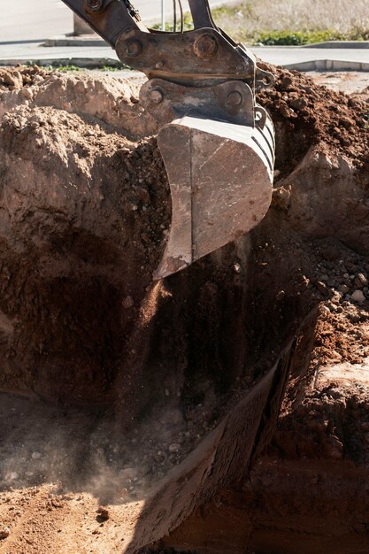 Excavatrice creusant dans le sol à la lumière du jour