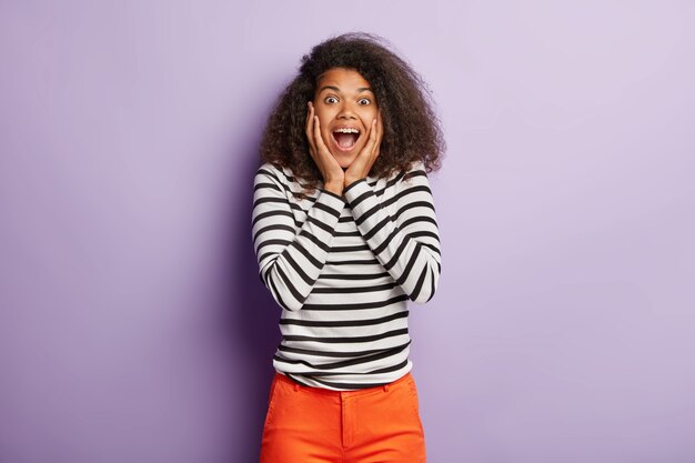 Excité belle femme avec une coiffure touffue bouclée