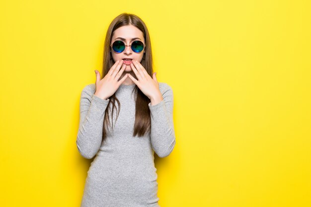 Excité de crier jeune femme debout isolé sur mur jaune