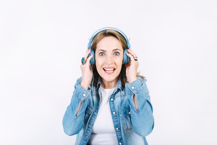 Photo gratuit excité femme écoutant de la musique