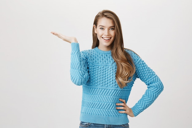 Excité femme souriante démontrant promo, pointant vers la gauche