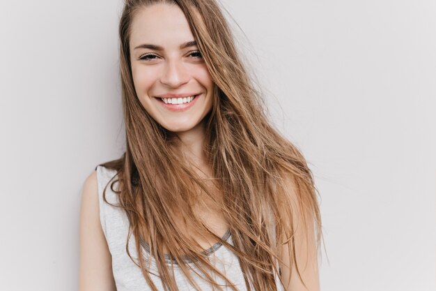 Excité fille caucasienne avec sourire joyeux posant. portrait de jolie femme aux cheveux longs aux yeux bruns.