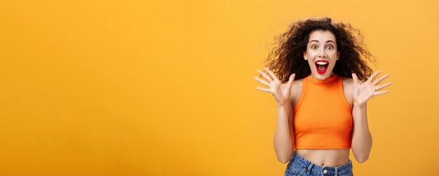 Excité impressionné jolie femme élégante avec anneau de nez rouge à lèvres et coiffure frisée souriant un