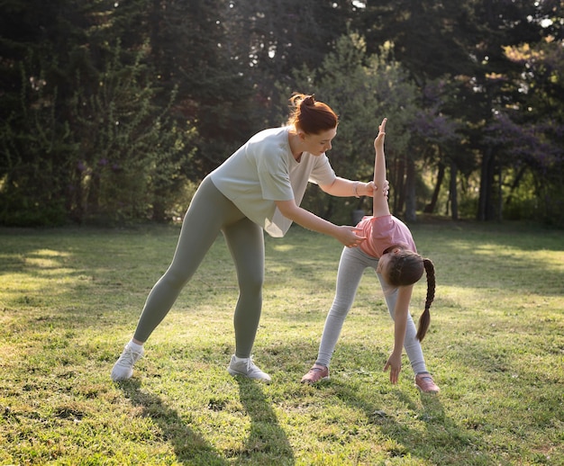 Photo gratuite exercice de plein air femme et enfant à l'extérieur