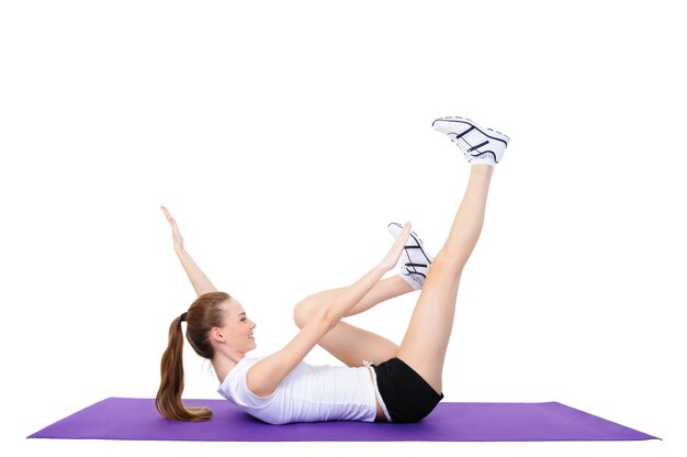 Exercices physiques de la belle jeune femme - isolé sur blanc