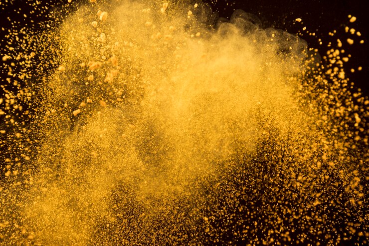 Photo gratuit explosion orange de poudre cosmétique sur fond sombre
