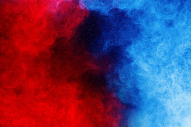 Explosion de poudre de couleur bleue et rouge sur fond noir
