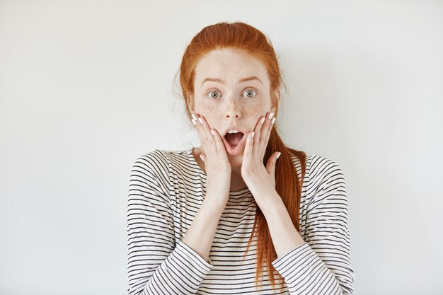 Expressions et émotions du visage humain. Rousse jeune femme avec des taches de rousseur et des ongles blancs hurlant de choc