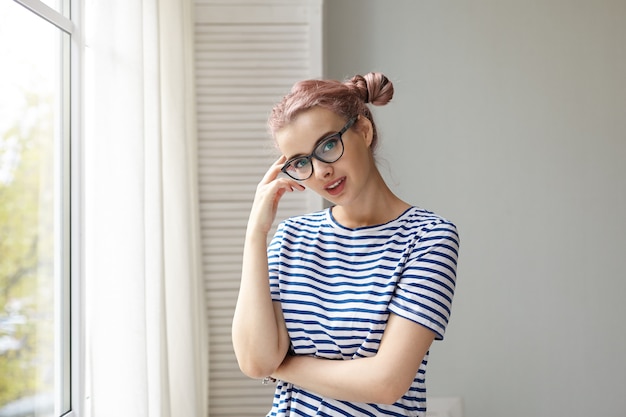 Expressive jeune fille posant à l'intérieur