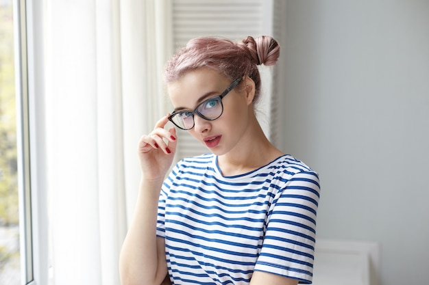 Expressive jeune fille posant à l'intérieur