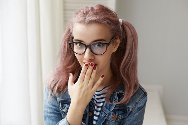 Expressive jeune fille posant à l'intérieur