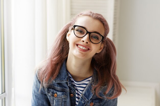 Expressive jeune fille posant à l'intérieur