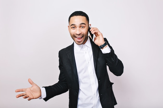 Exprimant de vraies émotions positives lumineuses du jeune homme d'affaires prospère parlant au téléphone. Travailleur moderne élégant, gestionnaire, succès, joie, bonheur.