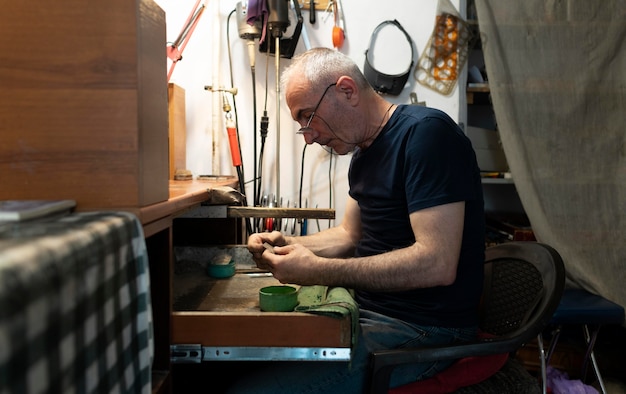 Fabricant de bijoux travaillant seul dans l'atelier