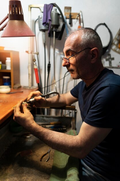 Fabricant de bijoux travaillant seul dans l'atelier