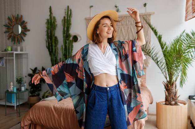 Fabuleuse femme aux cheveux courts s'amuser avec plaisir dans une maison confortable