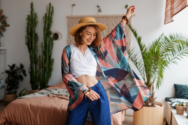 Fabuleuse femme aux cheveux courts s'amuser avec plaisir dans une maison confortable