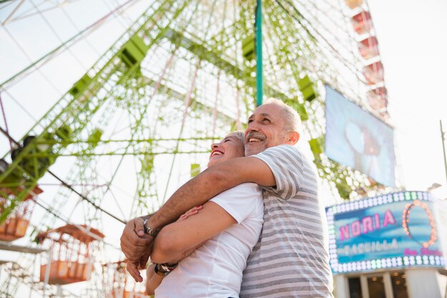 Faible angle couple heureux embrassant près de la grande roue