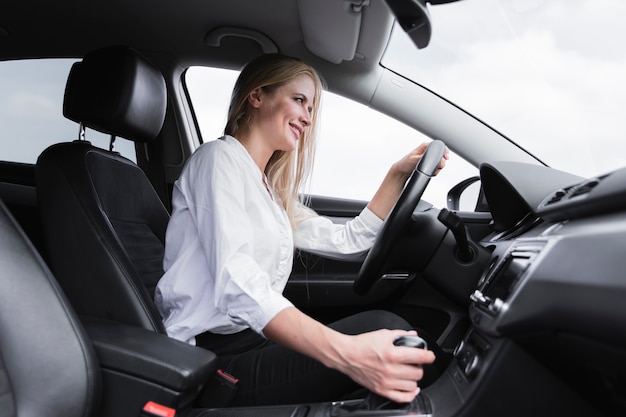 Faible angle d'une femme blonde au volant