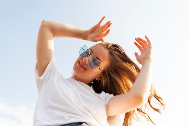 Faible angle de femme posant tout en profitant de son temps à l'extérieur