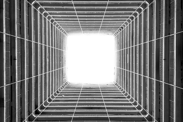 Photo gratuite faible angle de tir en niveaux de gris de la lumière entrant par le plafond d'un grand bâtiment