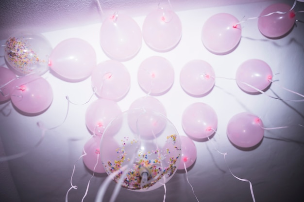 Photo gratuite faible angle de vue de ballons blancs et roses touchant au plafond