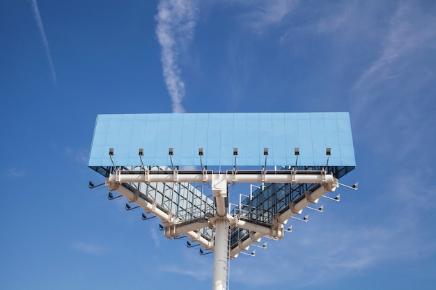 Photo gratuite faible angle de vue du grand poteau bleu de thésaurisation avec la lumière contre le ciel bleu