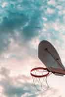 Photo gratuite faible angle de vue du panier de basket-ball contre le ciel nuageux