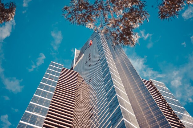 Faible angle de vue d'un grand immeuble commercial avec un ciel bleu nuageux