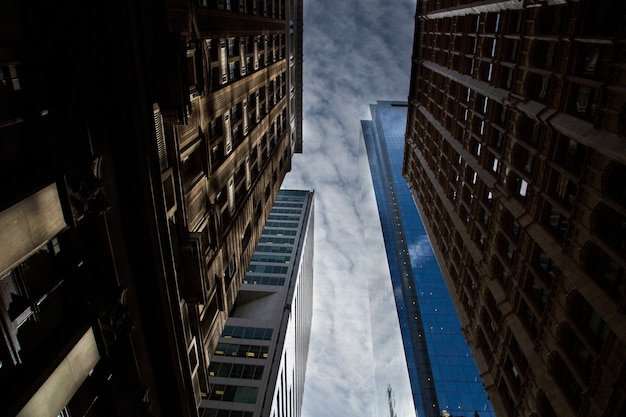 Faible angle de vue horizontal des immeubles de grande hauteur réfléchissants sous le ciel nuageux à couper le souffle