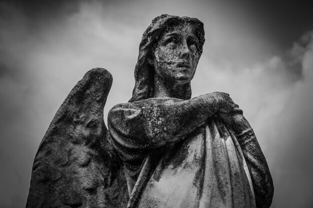 Faible angle de vue d'une statue féminine avec des ailes en noir et blanc