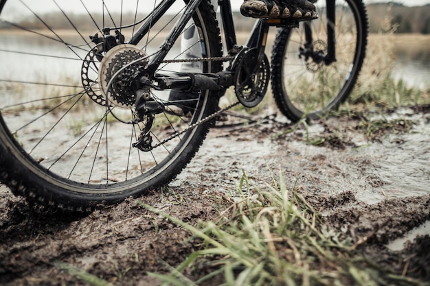 Faible section des pieds du cycliste à vélo dans la boue