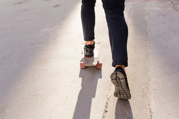 Faible section vue des pieds d&#39;une personne patinage sur planche à roulettes en bois