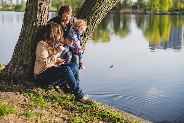 Famille assis à côté d&#39;un arbre