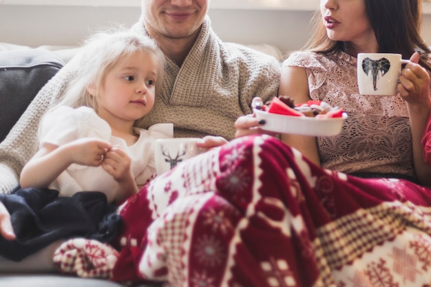 Famille assis ensemble sur le canapé à Noël