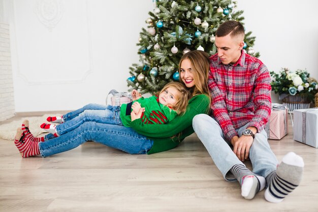 Famille assis en face de l&#39;arbre de Noël