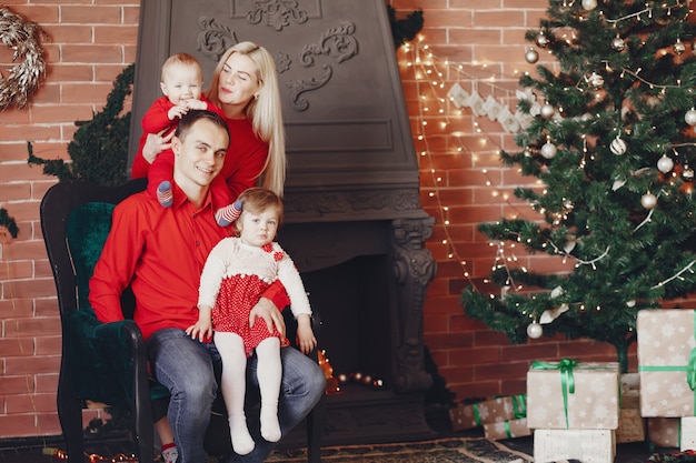 Famille assis à la maison près de sapin de Noël