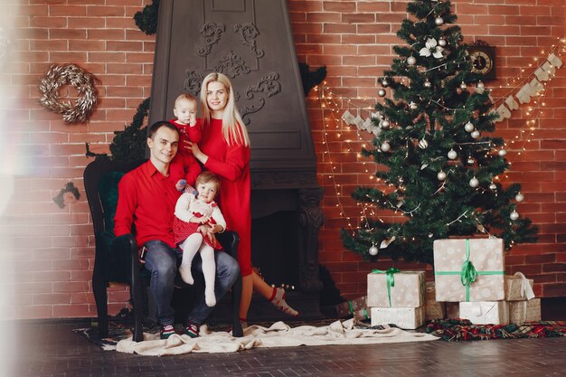 Famille assis à la maison près de sapin de Noël