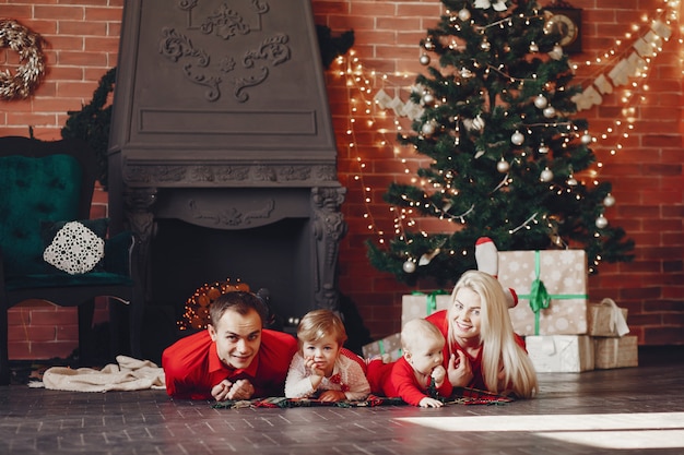 Famille assis à la maison près de sapin de Noël