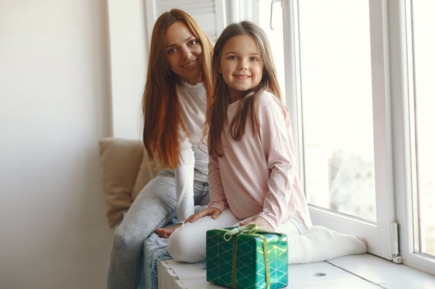 Famille assise à la maison avec des cadeaux