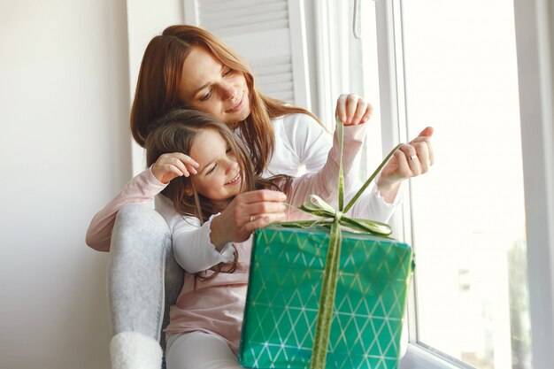 Famille assise à la maison avec des cadeaux