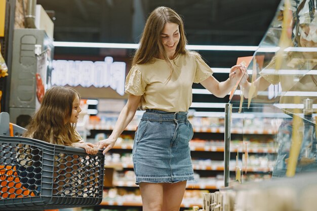 Famille au supermarché. Femme dans un t-shirt marron. Les gens choisissent les produits. Mère avec fille.