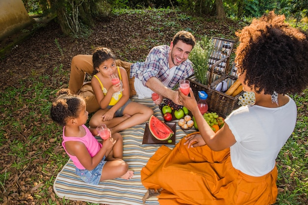 Photo gratuite famille ayant un pique-nique avec pastèque
