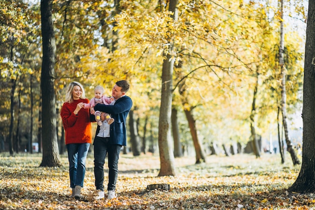 Famille avec bébé fille marchant dans un parc en automne