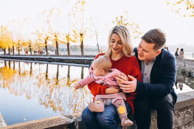 Famille avec bébé fille marchant dans le parc