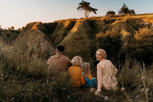 Famille complète assise sur l'herbe ensemble