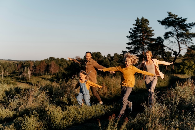 Famille complète en cours d'exécution sur le pré