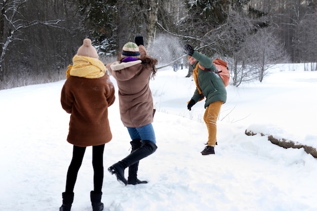 Famille complète jouant avec la neige